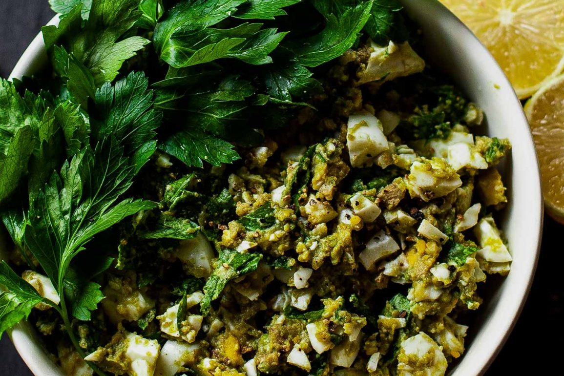 Bowl de ensalada de huevo perejil y aguacate con jugo de limón y pimienta