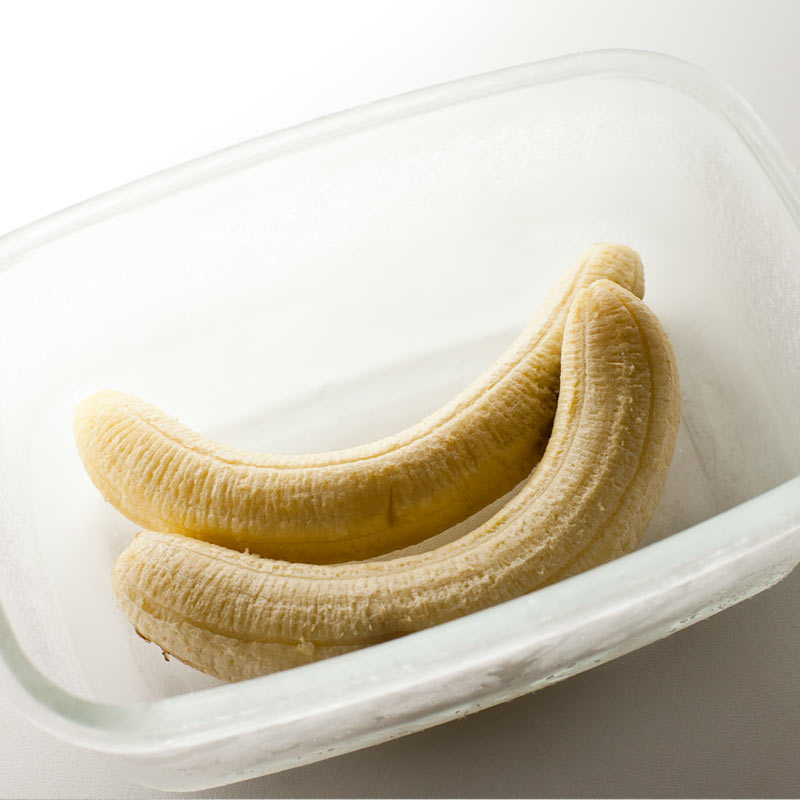 Plátanos congelados sin piel en recipiente de vidrio