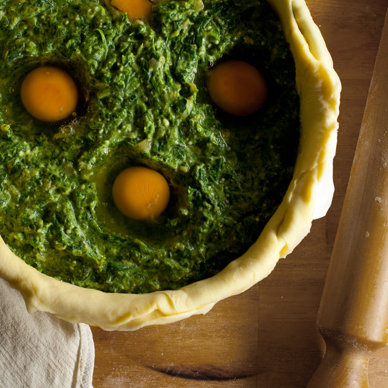 Torta pasqualina cruda con palo de amasar al costado