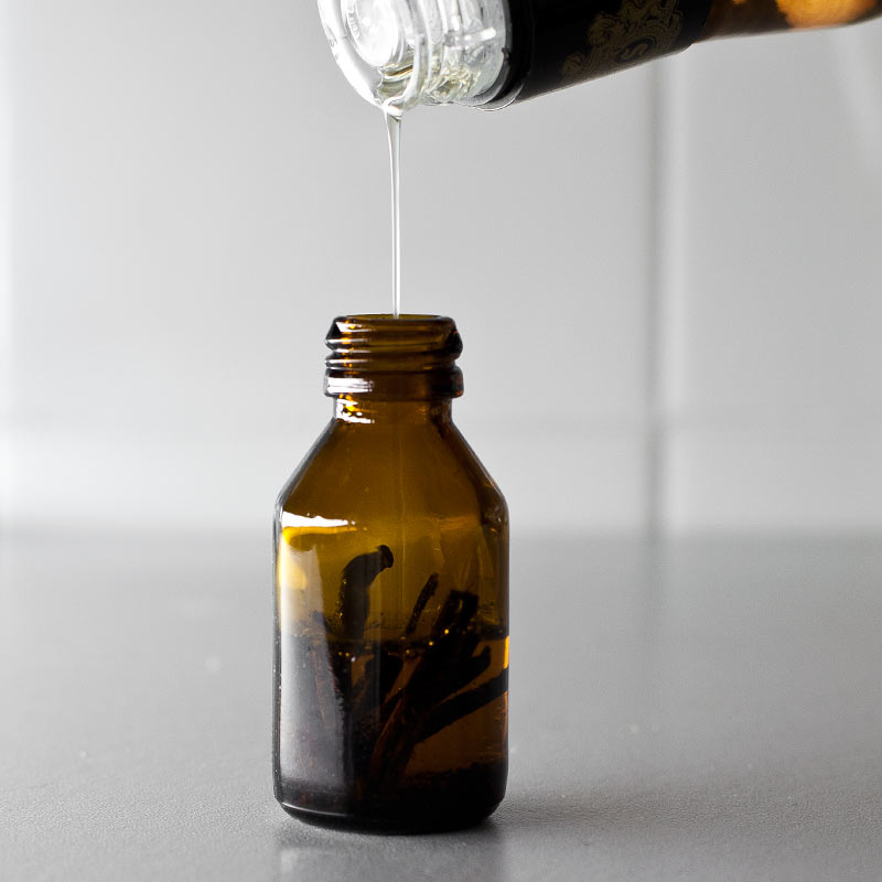 Whisky volcado en frasco con vaina de vainilla