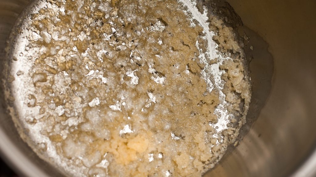 caramelo cristalizado en el fondo de una cacerola de acero