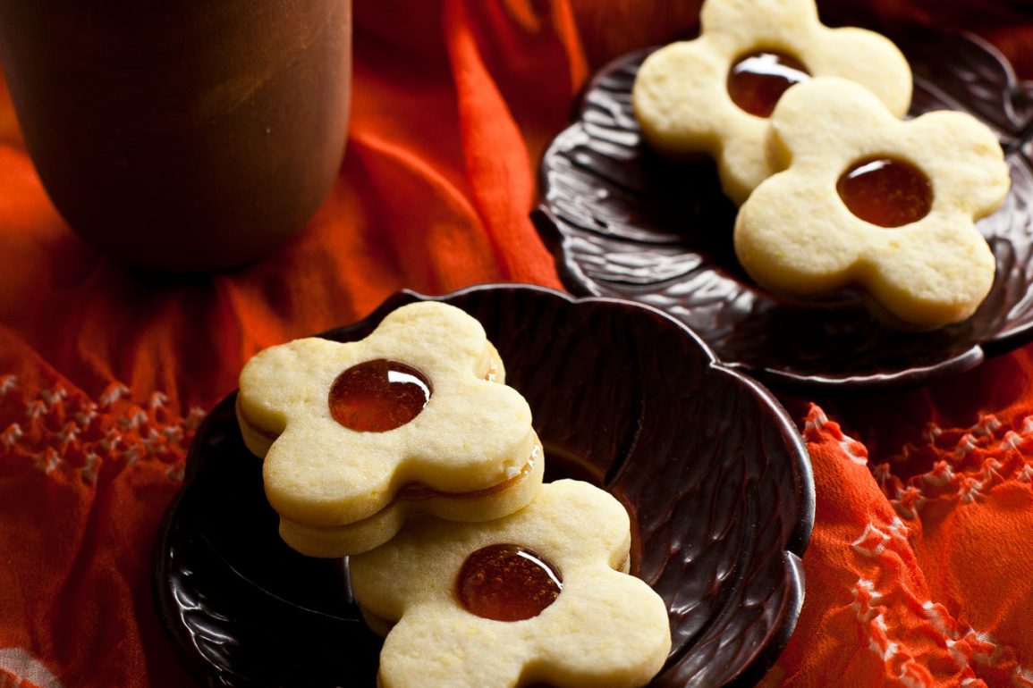 Galletas de masa sablée rellenas con jalea de membrillo sobre platos individuales