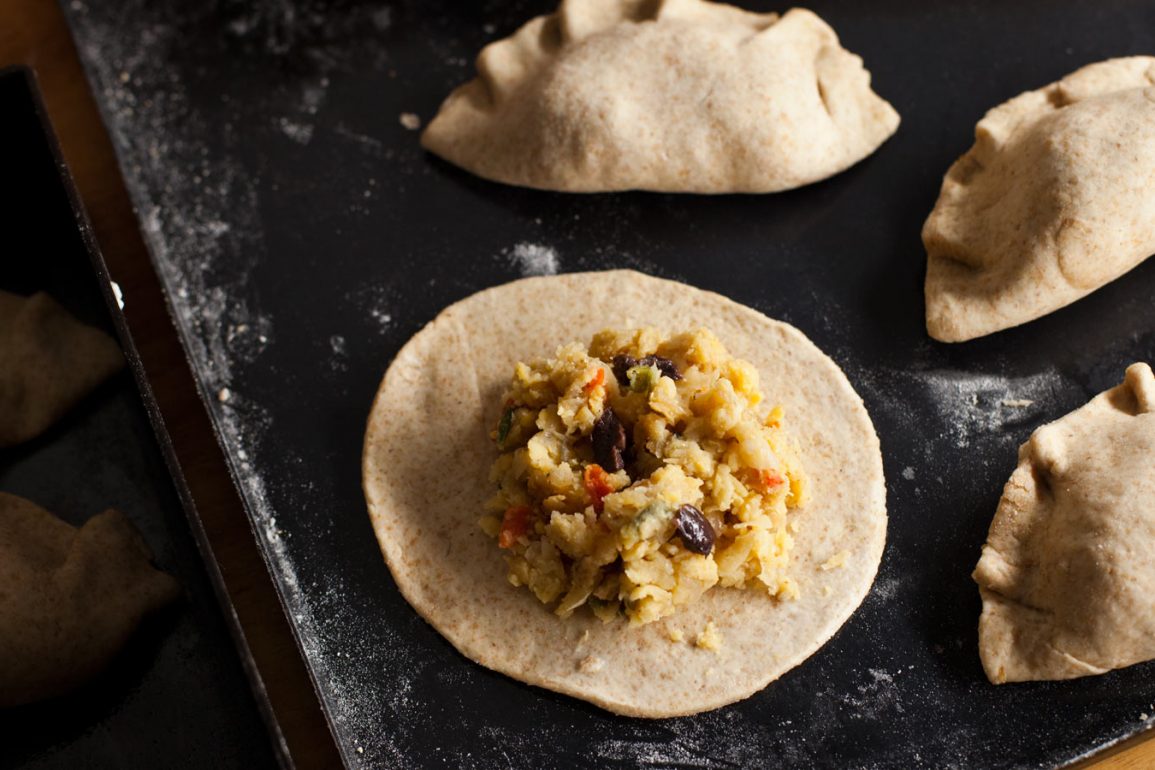 Relleno de garbanzo sobre tapa de empanada junto con empanadas